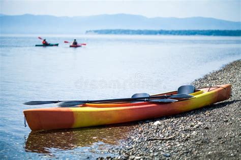 Kayak On The Sea Shore With Kayakers In The Background Stock Image