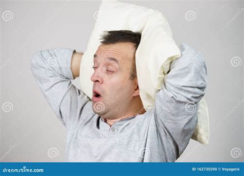 Man Sleepy Tired With Pillow Yawning On Grey Stock Photo Image Of