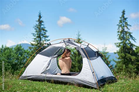 Back View Of Sporty Naked Female Tourist Sitting In Tent Enjoying
