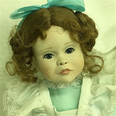 A Close Up Of A Doll Wearing A Blue Dress