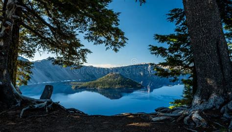 Reflective Blue Waters Of Crater Lake Between Pine Trees Stock Image