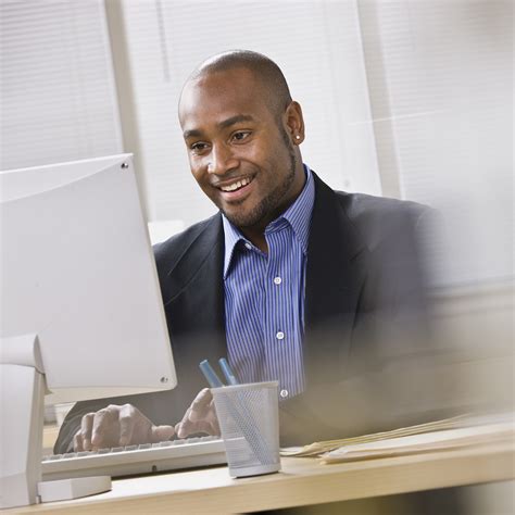Attractive African American Smiling At Computer While Sitting A Cc