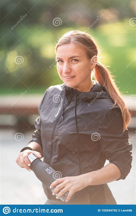 Happy Sportive Woman Drinking Water During Fitness