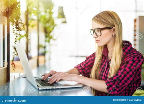 Young Female Entrepreneur Working Sitting At A Desk Typing On Her