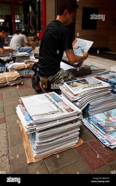 A Man Stacks And Packs Newspapers As Part Of The Delivery And