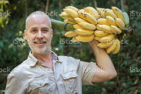 Man In Jungle Holding Bananas Stock Photo Download Image Now Adult