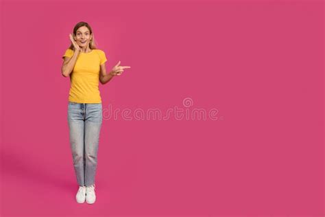 shocked cheerful middle aged european blonde female pointing finger at free space stock image