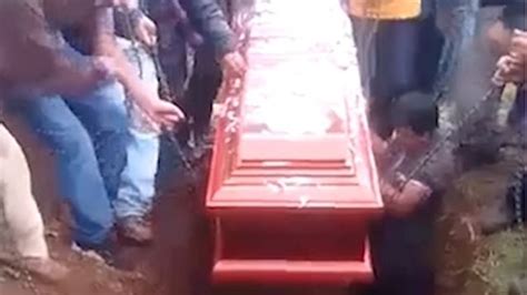watch pallbearers fall into grave and break coffin during funeral metro video