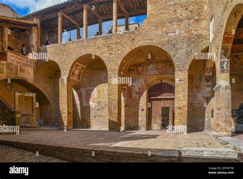 courtyard of palazzo comunale town hall with tourists lined up under the canopy to enter the