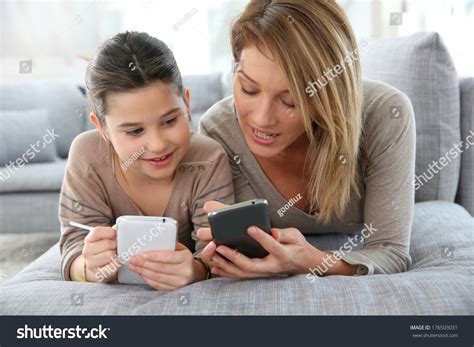 Mother And Daughter Playing Games With Smartphone Stock Photo 176503031