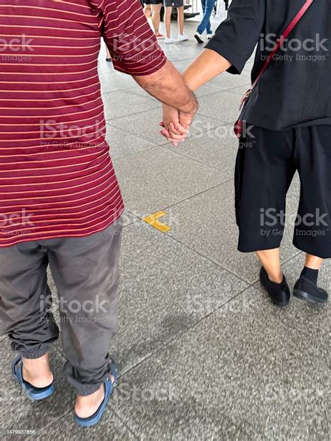 Gambar Pasangan Berpegangan Tangan Sambil Berjalan Di Lantai Beton