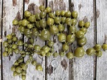 some green olives are on a wooden table