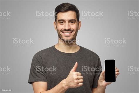 Cheerful Man Holding Phone With Black Screen Smiling At Camera Showing