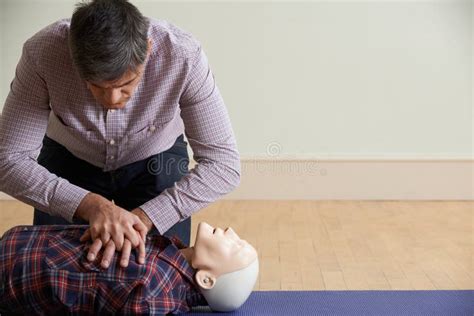 Man In First Aid Class Performing Mouth To Mouth Resuscitation O Stock