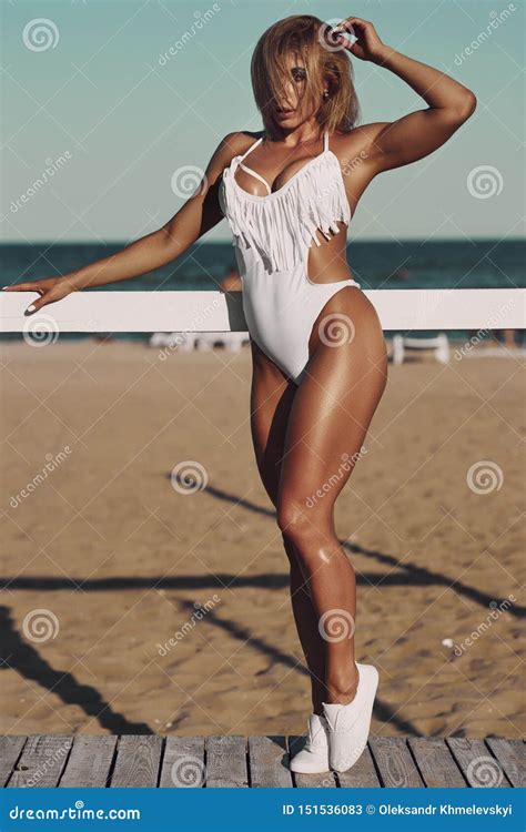 Amazing Woman In White Swimsuit With Perfect Sport Body Posing At The