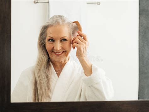 Woman Holding A Wood Comb In The Bathroom Aged Female Combing Her Hair