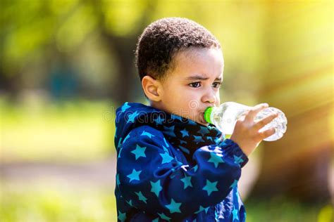 Little Boy Drinking Water From Bottle In A Park Stock Photo Image Of