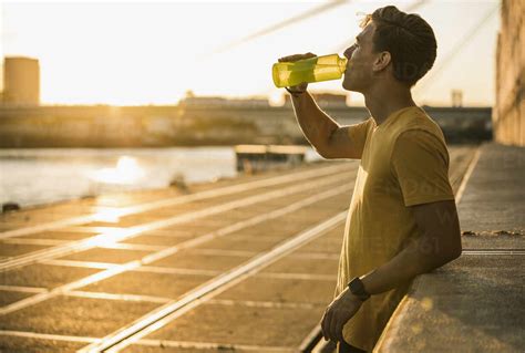 Man Drinking Water After Workout Against Clear Sky Stock Photo
