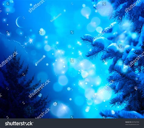 Snow Covered Christmas Tree On A Blue Night Sky Background Stock Photo