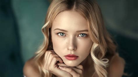 Grey Eyes Blonde Girl Model With Red Lipstick Is Sitting In Blur