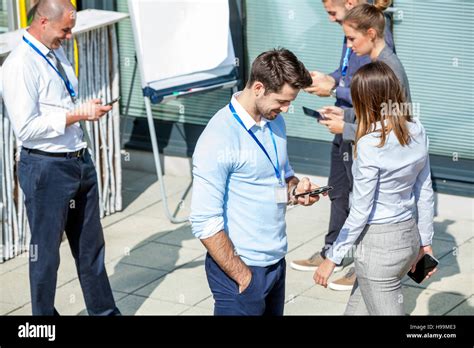 Group Of Business People Using Smartphones And Digital Tablets Outdoors