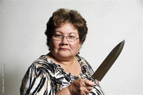 An Older Hispanic Woman With A Serious Look And Knife Stock Photo And