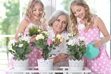 Premium Photo Granny With Granddaughters Watering Flowers