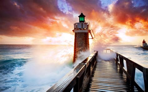 Lighthouse In Stormy Sea At Sunset