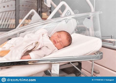 Happy Newborn Baby Boy Sleeping In A Hospital Room Bed Stock Photo