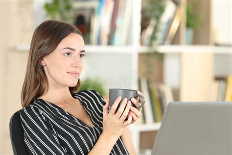 Relaxed Woman Holding Coffee Mug Contemplating At Home Stock Photo