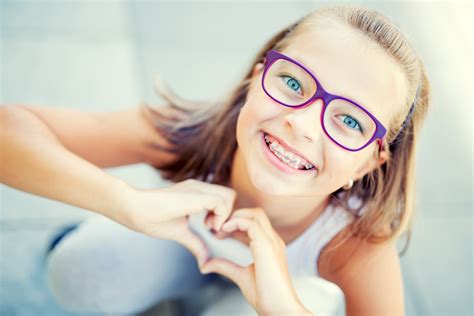 Smiling Little Girl In With Braces And Glasses Showing