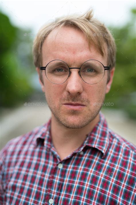 Portrait Of Man With Blonde Hair Wearing Eyeglasses Outdoors Stock