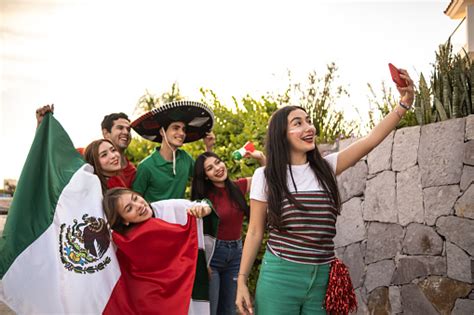 teenager latin friends taking selfies celebrating the mexican soccer team win outdoors stock