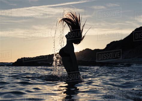 Silhouette Of A Woman In Waist Deep Water Flipping Her Wet Long Hair Up In The Air Tarifa