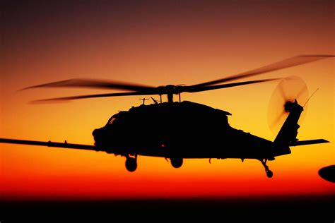 A Uh 60 Black Hawk Helicopter Moves Behind The Fuel Hose Of A Kc 130j