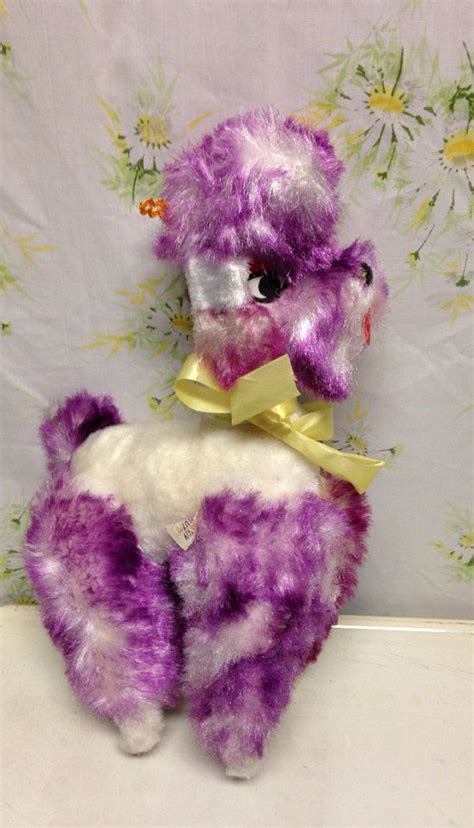 A Purple And White Stuffed Animal With A Yellow Bow On Its Neck Sitting