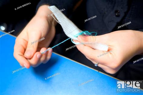 Primary School Pupil Learning To Sew During A Needlework Lesson At