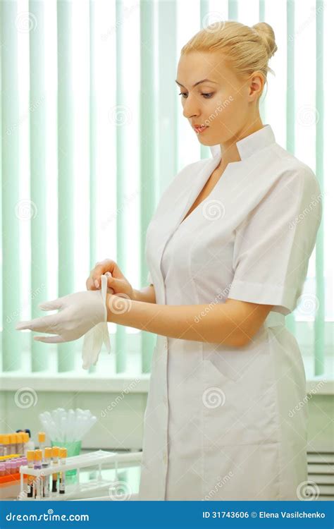 Medical Doctor Womanputs On Latex Gloves Royalty Free Stock Image
