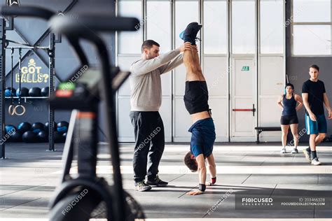 Man In Gym Helping Friend Do Handstand — Mid Adult Man Balance Stock