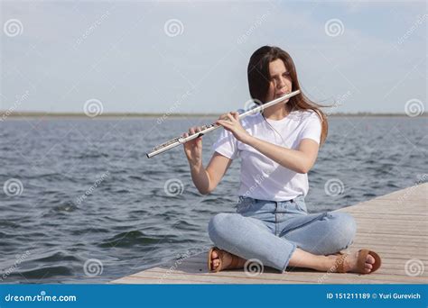 A Beautiful Woman Posing In Beach While Playing On A Flute Stock Image