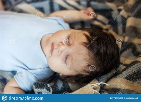 Little Baby Sleeping Calm In Bed At Home Blue And White Blanket