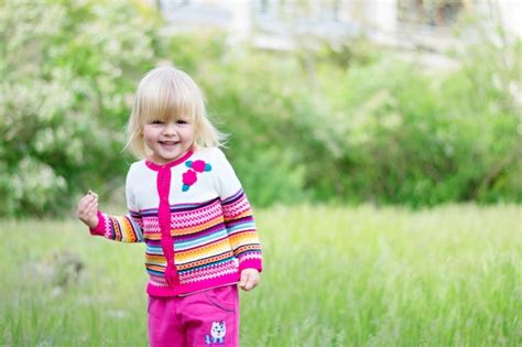 Premium Photo Beautiful Little Girl Walks On The Grass In Spring