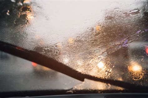 Drops Of Rain Drizzle On The Glass Windshield In The Evening Street In