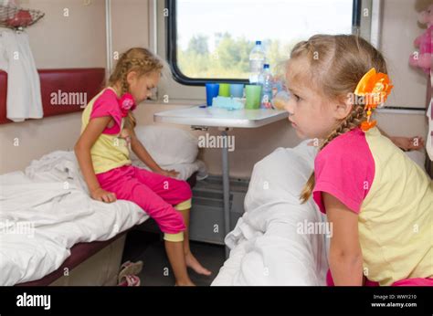 two girls sisters on the train on the lower ground in the second class compartment wagon stock