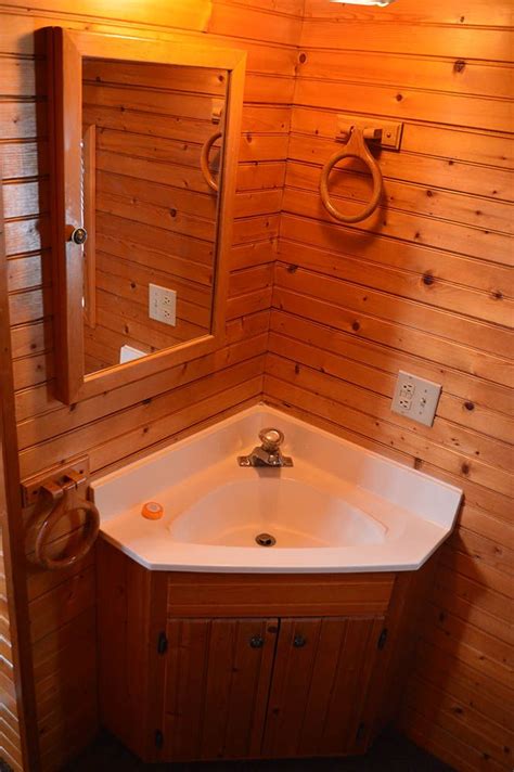 A Bathroom With Wooden Walls And A White Sink