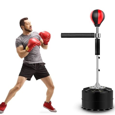 A Man Wearing Red Boxing Gloves Standing Next To A Punching Device