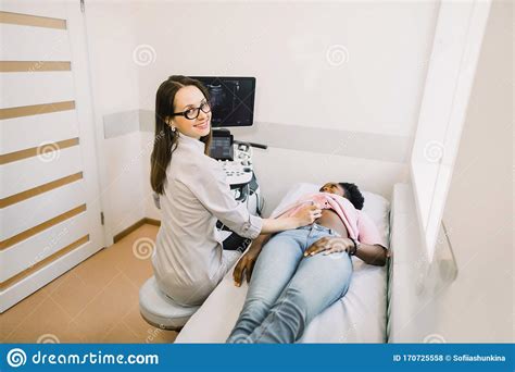 Smiling Woman Doctor Conducting Ultrasound Examination Of Patient S