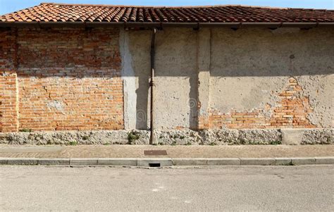 Old Wall With Peeled Plaster And Exposed Bricks Porphyry Sidewalk And