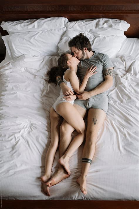 Young Couple Kissing And Hugging On Morning Bed By Alberto