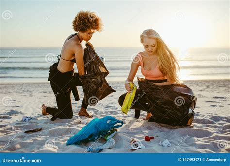 girls picking up trash from the beach stock image image of litter outdoors 147493971